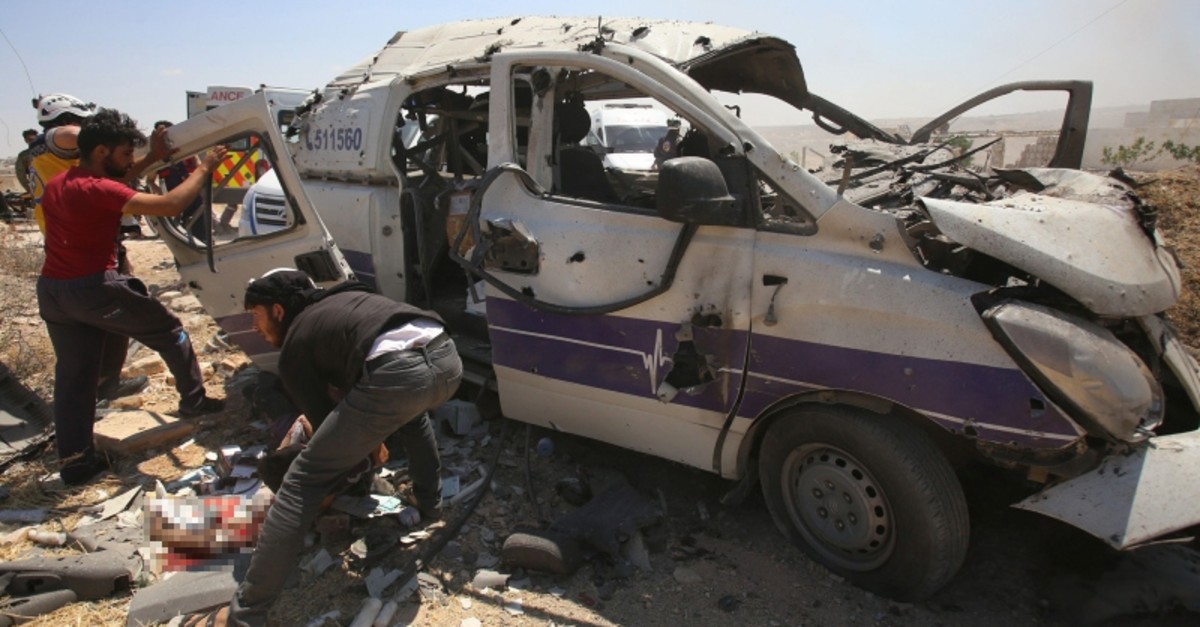 Syrian rescuers help a badly wounded man following a regime air strike which targeted an ambulance in the town of Maaret al-Numan in northwest Syria on June 20, 2019. (AFP Photo)