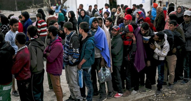 Refugees and migrants line up for a food distribution at the Moria refugee camp on the Greek island of Lesbos, November 5, 2015. (Reuters Photo)