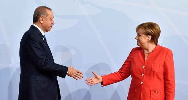 أردوغان يصافح ميركل قبل بدء اجتماعات مجموعة العشرين G20  في مدينة هامبرغ شمالي ألمانيا يوليو 2017 وكالة الأنباء الفرنسية