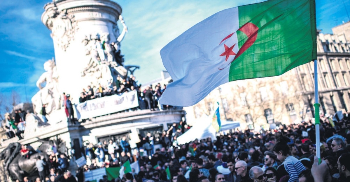 A protester holds up the Algerian flag during a rally against the Algerian president's bid for a fifth term in office, at the Place de la Republique in Paris, February 24, 2019.