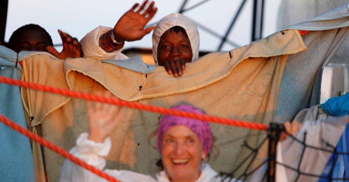 A crew member and rescued migrants wave on the migrant rescue ship 'Alan Kurdi', operated by German NGO Sea-Eye, wave after a delivery of supplies by the NGO Migrant Offshore Aid Station (MOAS) off the coast of Malta (Reuters Photo)