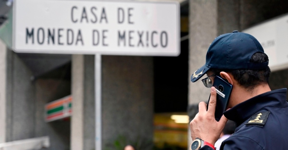 A policeman speaks on his mobile phone outside Mexico's Casa de Moneda, in Mexico City on August 6, 2019, which was robbed earlier today and the assailants took a swag of approximately two and a half million dollars in gold coins. (AFP Photo) 