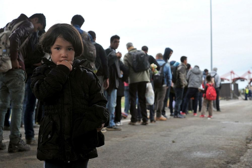 A migrant girl together with a group of Middle Eastern migrants wait to cross the Hungarian-Croatian border.