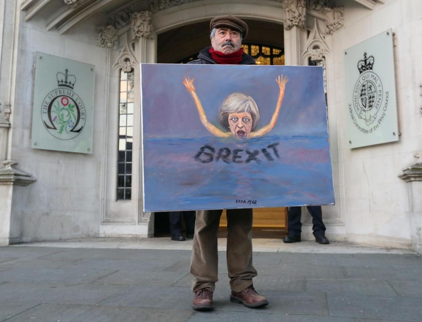 Satirical artist Kaya Mar poses with a Brexit-themed artwork depicting British PM Theresa May, as he stands outside the Supreme Court in London in January (AFP Photo)