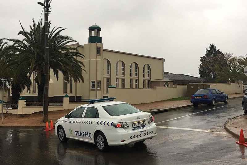 In this picture taken with a phone a South African police vehicle is parked outside the Malmesbury main mosque following a stabbing attack that left two worshippers dead on June 14, 2018 in Malmesbury, north of Cape Town. (AFP Photo)