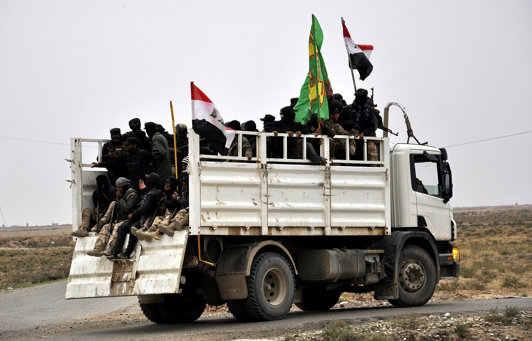 Fighters of Iraqi Shiite militias who volunteered to support the Iraqi forces ride a truck as they make their way towards Daquq town near Tikrit city, northern Iraq, 08 February 2015. (EPA Photo)