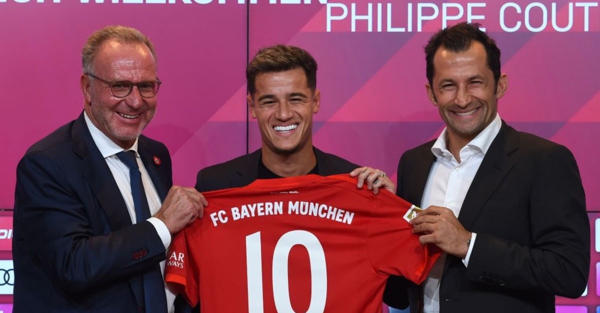 Bayern Munich CEO Karl-Heinz Rummenigge (L), sports director Hasan Salihamidzic (R) and Philippe Coutinho, pose with his jersey in the stadium in Munich, Aug. 19, 2019.