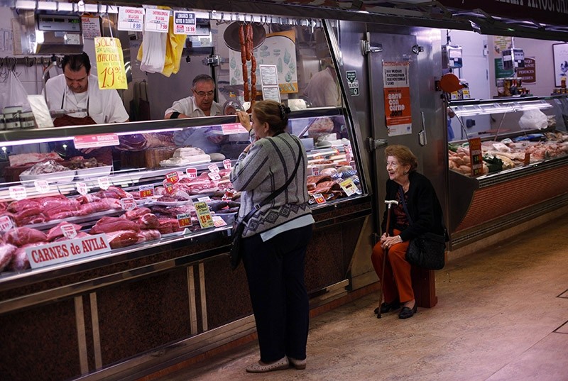 Customers buy meat at a butcher at Madrid's Chamberi market April 12, 2011. (Reuters Photo)