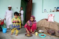 A Rohingya refugee feeds her daughter in a building on the outskirts of Srinagar on September 14, 2017. (AFP Photo)
