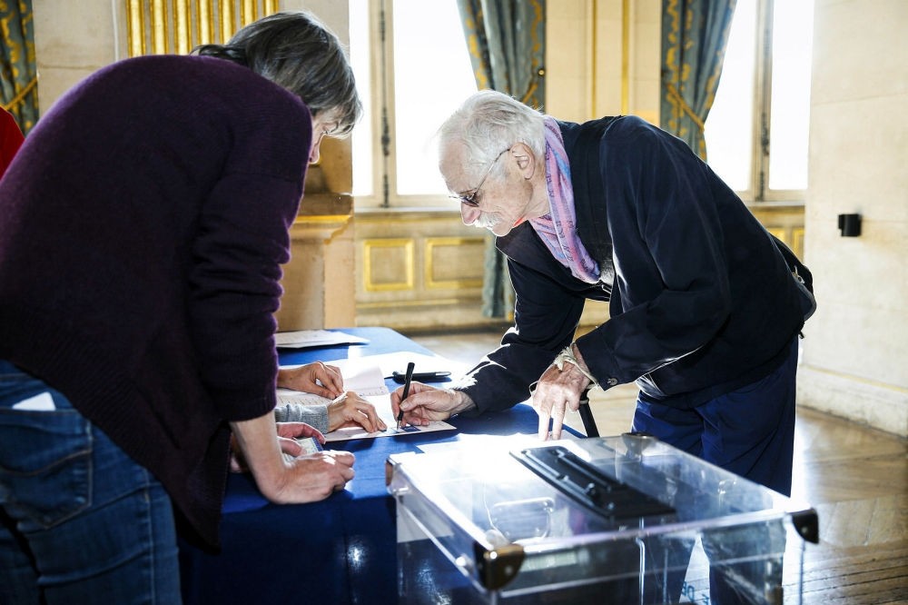 A man signs his name before casting his ballot for the French Senate elections at the Hotel de Ville of Paris on Sept. 24.