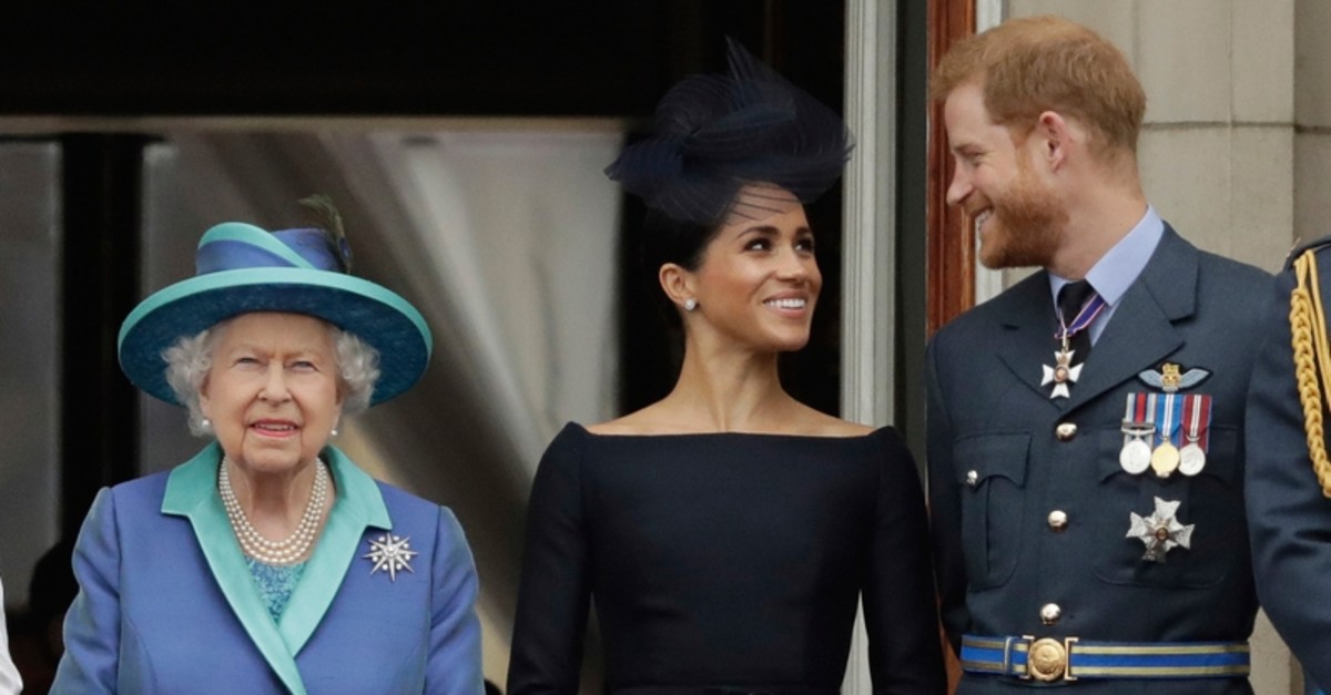 In this Tuesday, July 10, 2018 file photo Britain's Queen Elizabeth II, and Meghan the Duchess of Sussex and Prince Harry watch a flypast of Royal Air Force aircraft pass over Buckingham Palace in London. (AP Photo)