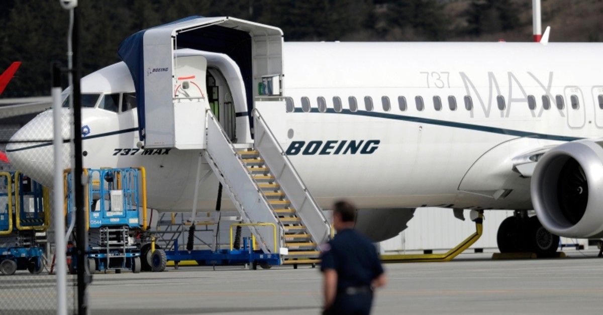 A worker walks next to a Boeing 737 MAX 8 airplane parked at Boeing Field, Thursday, March 14, 2019, in Seattle (AP Photo)