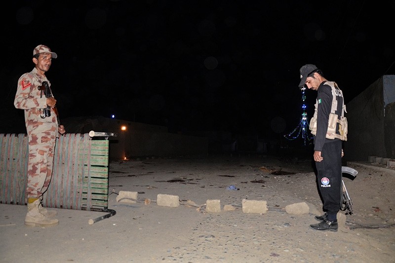 A Pakistani security personnel (L) and a policeman stand guard at the site of a suicide attack, outside a Sufi shrine in Jhal Magsi district in Balochistan province, on Oct. 5, 2017. (AFP Photo)