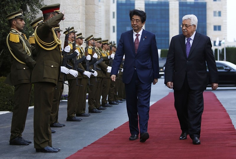 Japanese Prime Minister Shinzo Abe (C) walks with Palestinian president Mahmud Abbas (R) during a welcome ceremony in the West Bank city of Ramallah (AFP Photo)