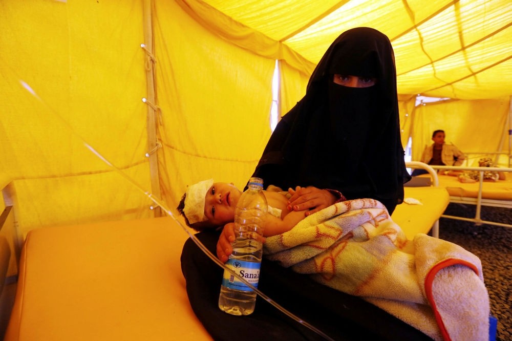 A Yemeni woman holds her cholera-infected child inside a makeshift tent at a hospital in Sanaa, Yemen, July 22.