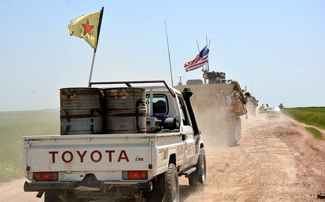 A convoy of US army troops and militants from PKK's Syrian offshoot the People's Protection Units (YPG) patrol near al-Ghanamya village, al-Darbasiyah town at the Syrian-Turkish border, Syria, April 29, 2017. (EPA Photo)