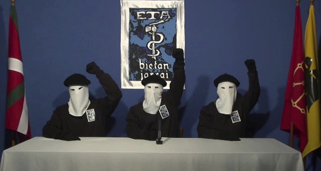 In this file image made from video provided on Oct. 20, 2011, masked members of the Basque separatist group ETA hold up their fists in unison following a news conference at an unknown location. (AP Photo)