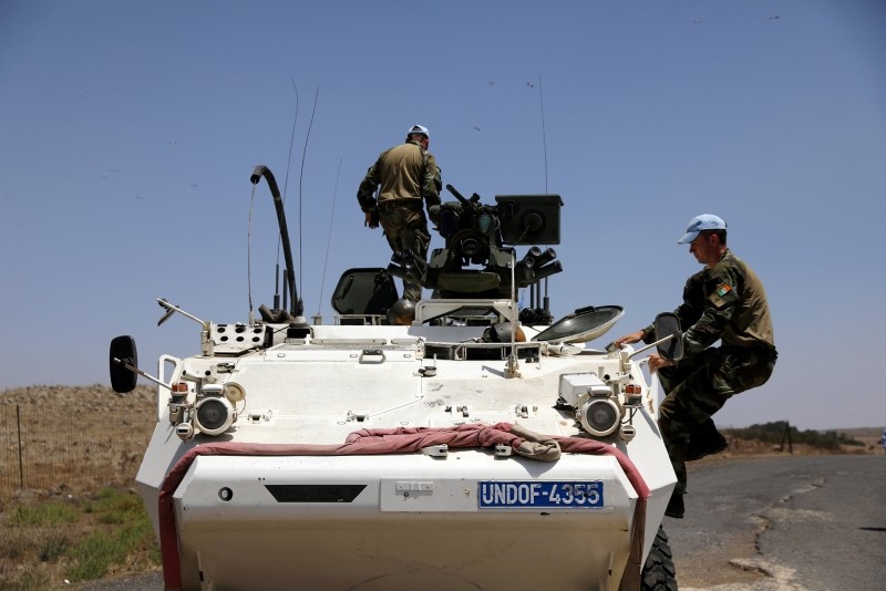 U.N. Disengagement Observer Force (UNDOF) climb onto an APC after they crossed the border from Syria to Israel at the Israeli-occupied Golan Heights side, July 26, 2018. (Reuters Photo)