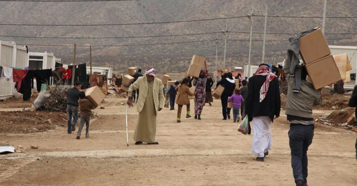 Displaced Iraqi people from the minority Yazidi sect, fleeing violence in the Iraqi town of Sinjar west of Mosul, walk to the Qadia camp on the outskirts of Dohuk province, Dec. 7, 2014.