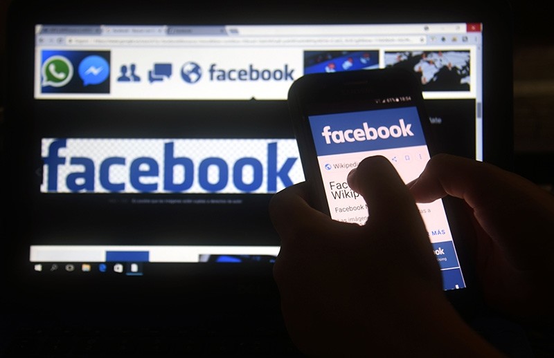 In this file photo taken on March 22, 2018 a cellphone and a computer screen display the logo of the social networking site Facebook in Asuncion. (AFP Photo)