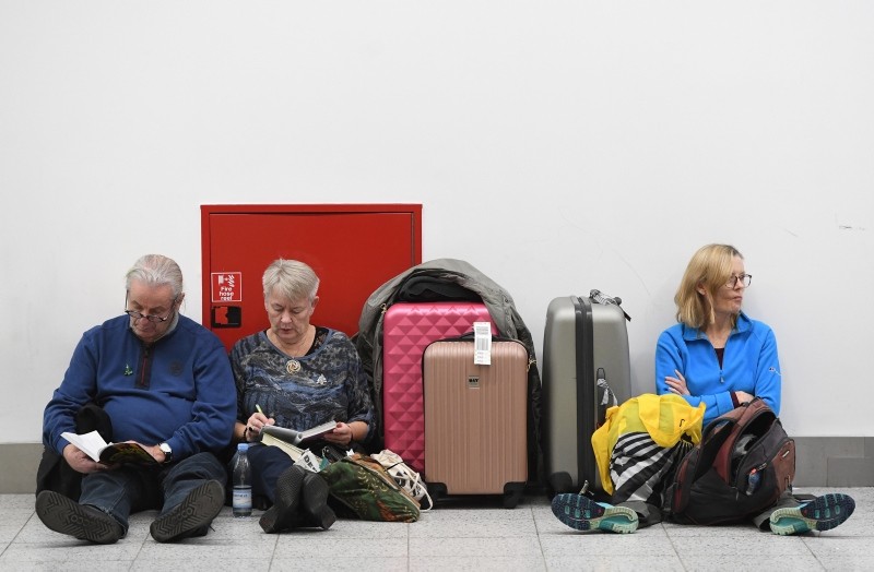 Passengers rest with their luggage at the Gatwick airport, after it reopens, in Sussex, December 21, 2018. (EPA Photo)