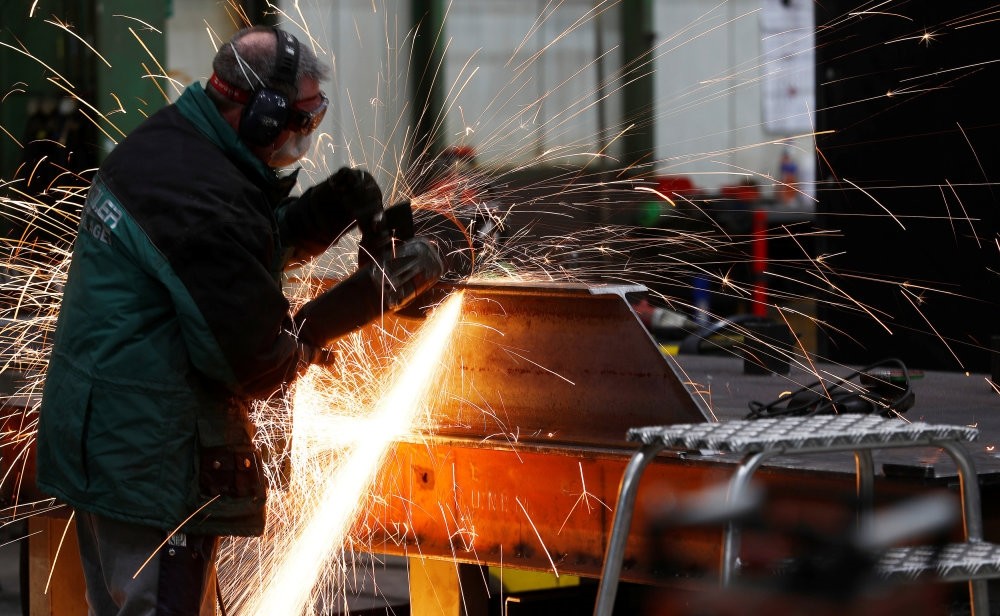 A worker grinds metal at the machine-building company Zemmler Siebanlagen in Massen, Germany.