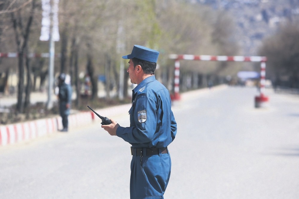 Police stand guard in the street after a suicide bombing in front of Kabul University, Kabul, Afghanistan, March 21, 2018. 