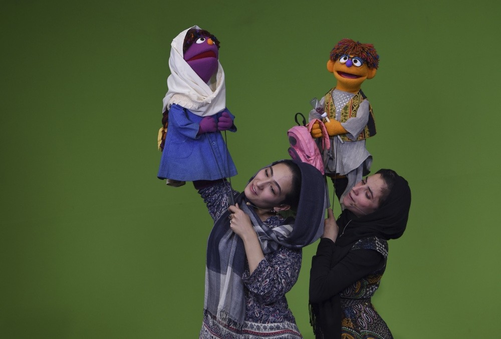 Afghan puppeteer Seema Sultani (R) holds new u201cSesame Streetu201d muppet u201cZeeraku201d as she performs with colleague  Mansoora Shirzad holding u201cZariu201d during a recording at the television studio in Kabul.