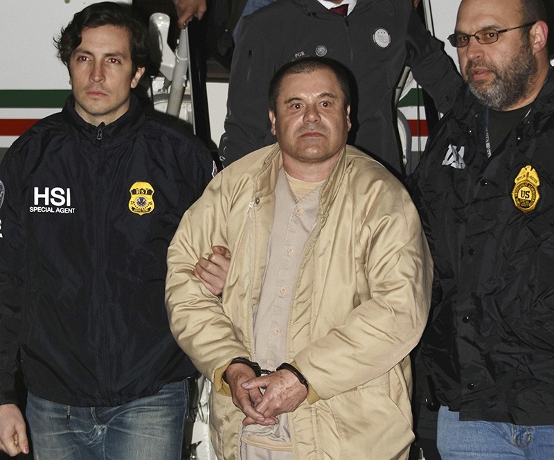 In this Jan. 19, 2017 photo provided by the United States Drug Enforcement Administration, authorities escort Joaquin ,El Chapo, Guzman, center, from a plane to a waiting caravan of SUVs at Long Island MacArthur Airport in Ronkonkoma, N.Y. (AP Photo)