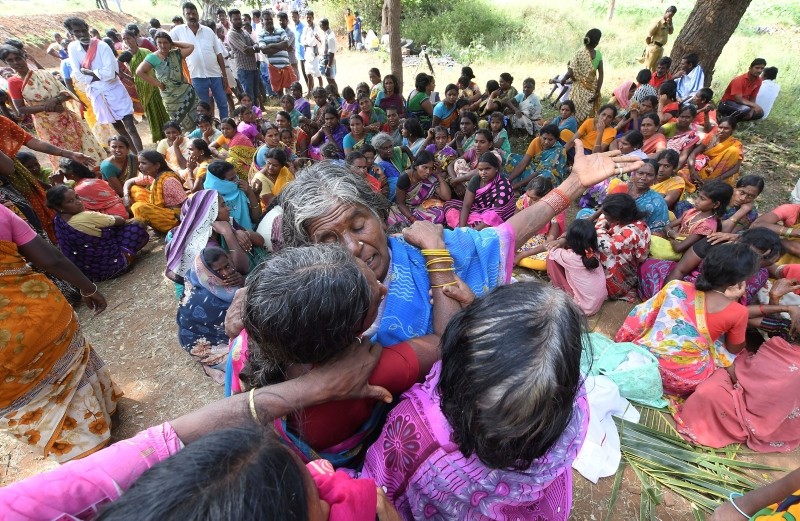 Indian women mourn the death of relatives in a case of suspected food poisoning at Bidarahalli, near Sulawadi village in Chamarajnagar district of Karnataka state, India, Saturday, Dec. 15, 2018. (AP Photo)
