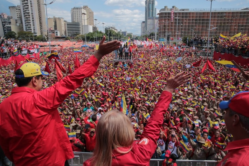 Handout picture released by the Venezuelan presidency showing Maduro (L) and his wife Cilia Flores wave at the crowd during a gathering to mark the 20th anniversary of the rise of power of the late Hugo Chavez, in Caracas on February 2, 2019 (AFP)
