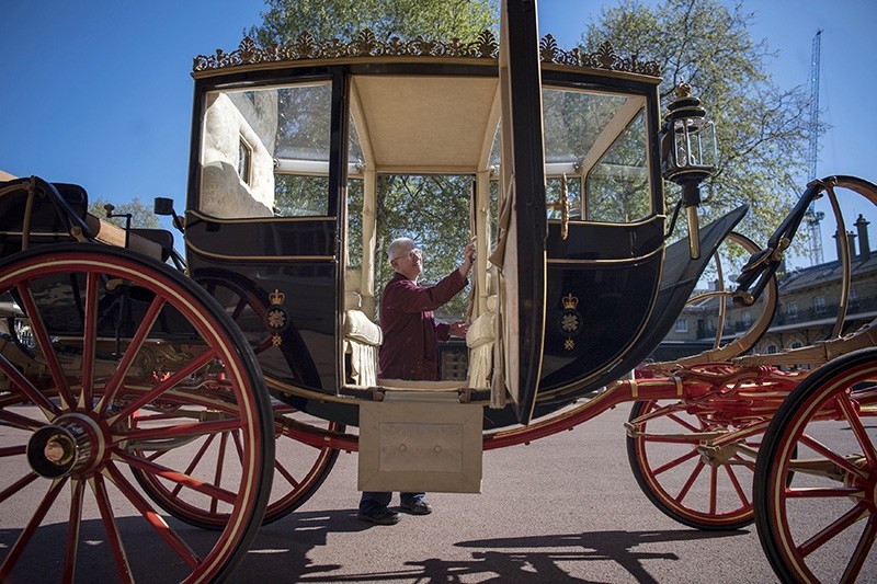 The Scottish State Coach, which will be used in the case of wet weather at the wedding of Britain's Prince Harry and Meghan Markle, is polished in the Royal Mews at Buckingham Palace in London, Tuesday May 1, 2018. (AP Photo)