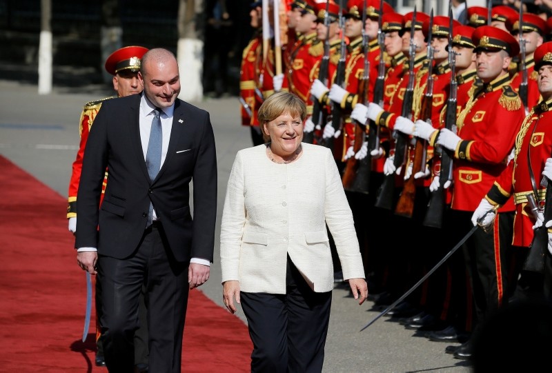 German Chancellor Angela Merkel (R) inspects a guard of honor with Georgian Prime Minister Mamuka Bakhtadze (L) during the official welcoming ceremony in Tbilisi, Georgia, 23 August 2018. (EPA Photo)