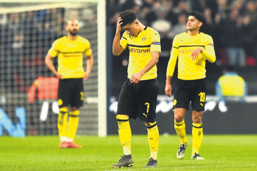 Dortmund's Jadon Sancho (L) and Mahmoud Dahoud react after conceding their second goal to Tottenham Hotspur, Feb. 13, 2019.
