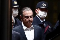 In this file photo taken on April 25, 2019, former Nissan chairman Carlos Ghosn (C) is escorted as he walks out of the Tokyo Detention House following his release on bail in Tokyo. (AFP Photo)