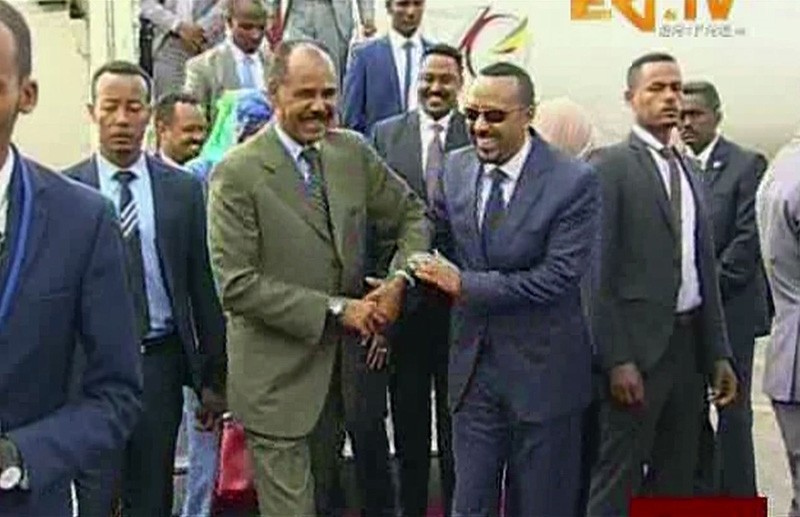 In this grab taken from video provided by ERITV, Ethiopia's Prime Minister Abiy Ahmed, centre right is welcomed by Erirea's President Isaias Afwerki as he disembarks the plane, in Asmara, Eritrea, Sunday, July 8, 2018. (ERITV via AP)