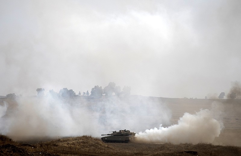 Israeli tanks train at the Golan Heights area, on the Israeli-Syrian border (EPA Photo)