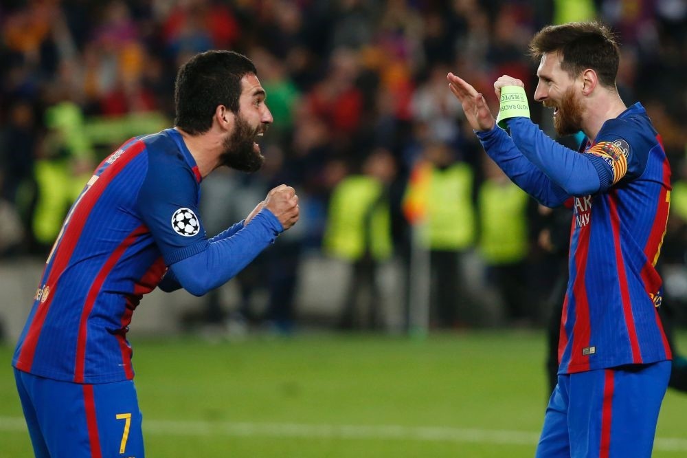 Barcelona's Argentinian forward Lionel Messi (R) celebrates with Barcelona's Turkish midfielder Arda Turan at the end of the UEFA Champions League round of 16 second leg football match FC Barcelona vs Paris Saint-Germain FC at the Camp Nou stadium.