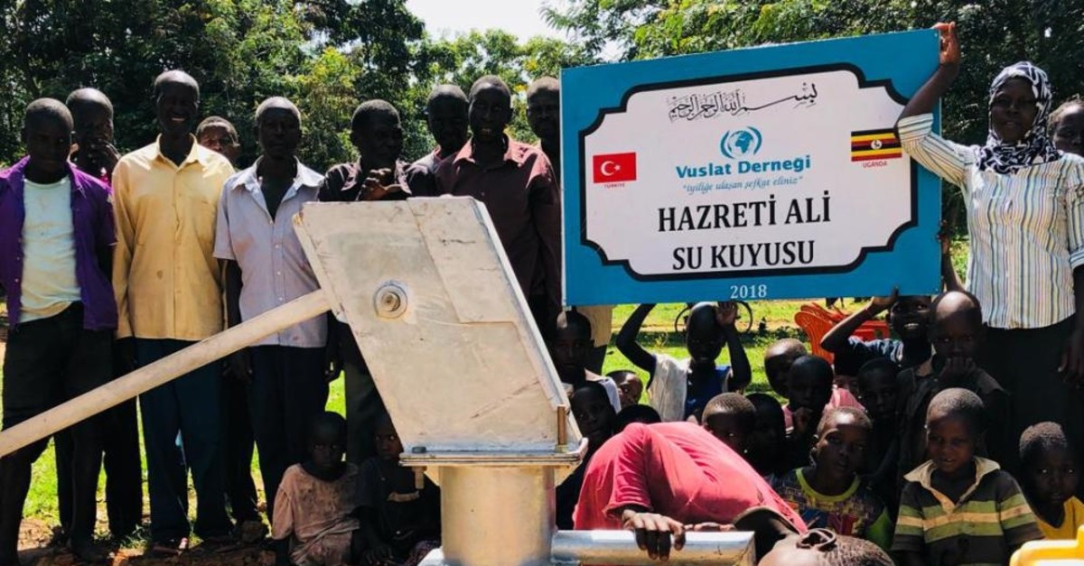 A child drinks from a water pump at a well drilled by the  Turkish charity Vuslat, during its inauguration in 2018 in Uganda.
