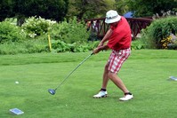A left-handed golfer hits the ball during a tournament.
