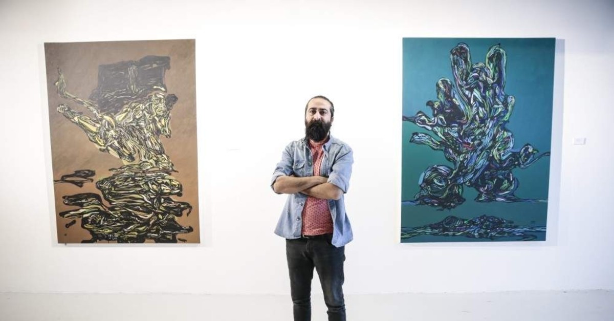 Adnan Jetto poses with some of his works at the exhibition. (AA Photo)