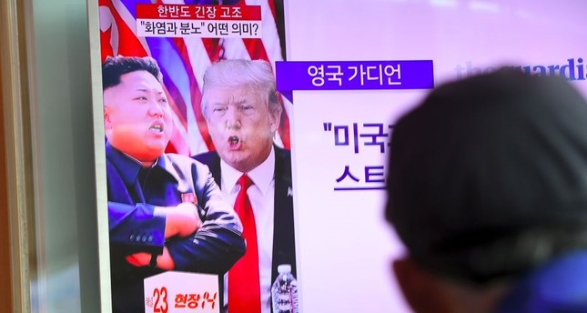 A man watches a television news program showing North Korean leader Kim Jong Un and U.S. President Donald Trump at a railway station in Seoul, Aug. 9, 2017.