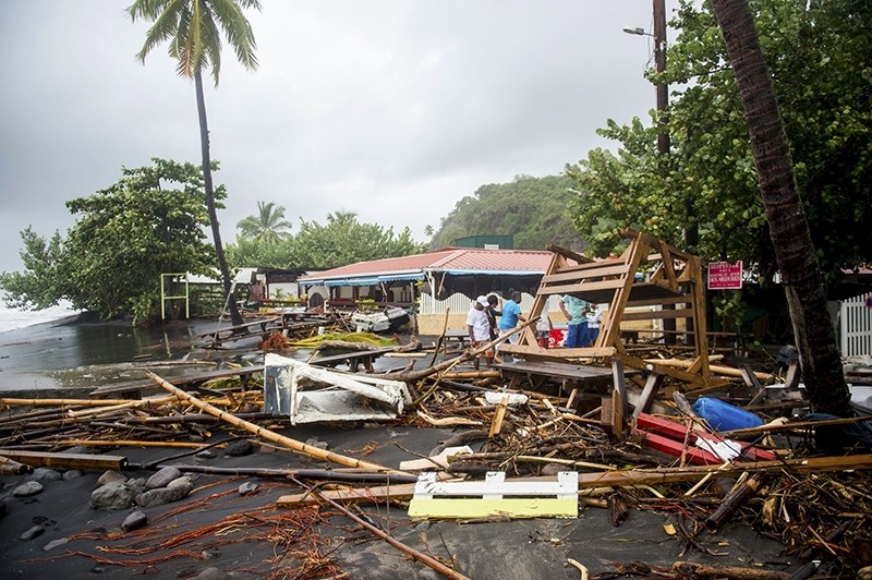 People stand next to debris at a restaurant in Le Carbet, on the French Caribbean island of Martinique, after it was hit by Hurricane Maria, on September 19, 2017. (AFP Photo)