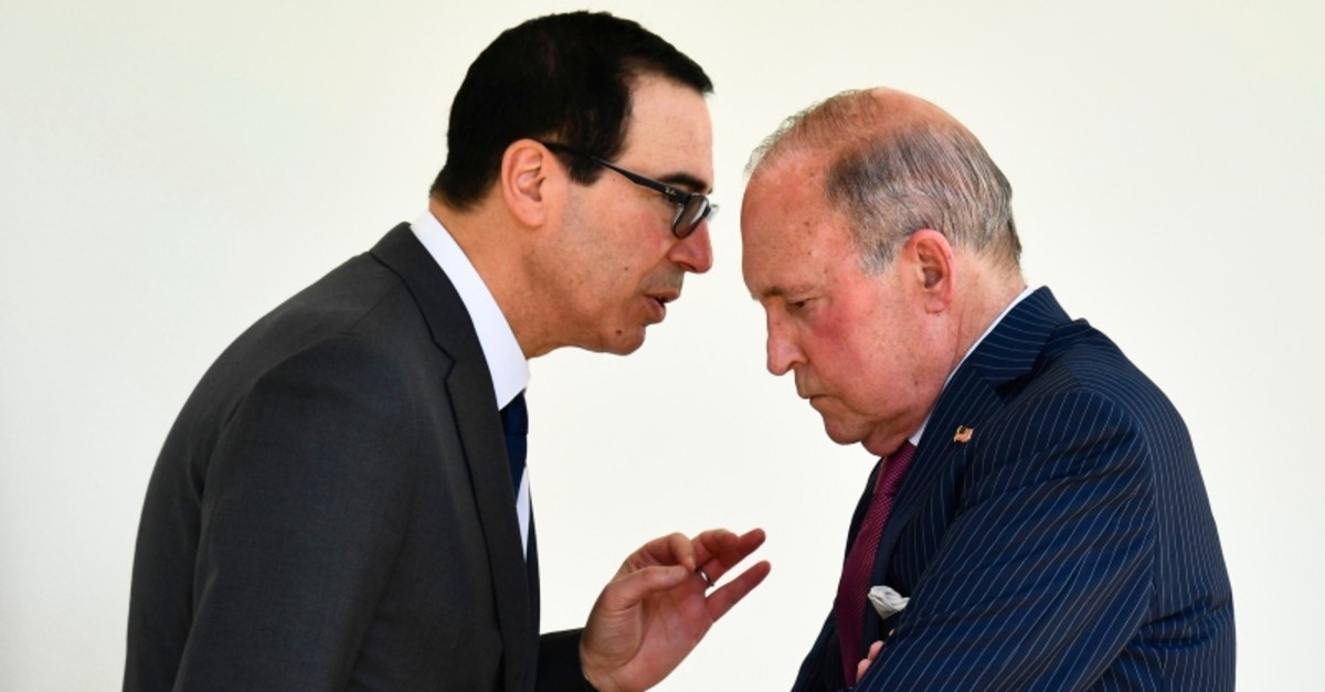 Treasury Secretary Steven Mnuchin, left, and White House chief economic adviser Larry Kudlow, right, talk along the colonnade following an immigration speech by President Donald Trump in the Rose Garden at the White House, May 16, 2019. (AP Photo)