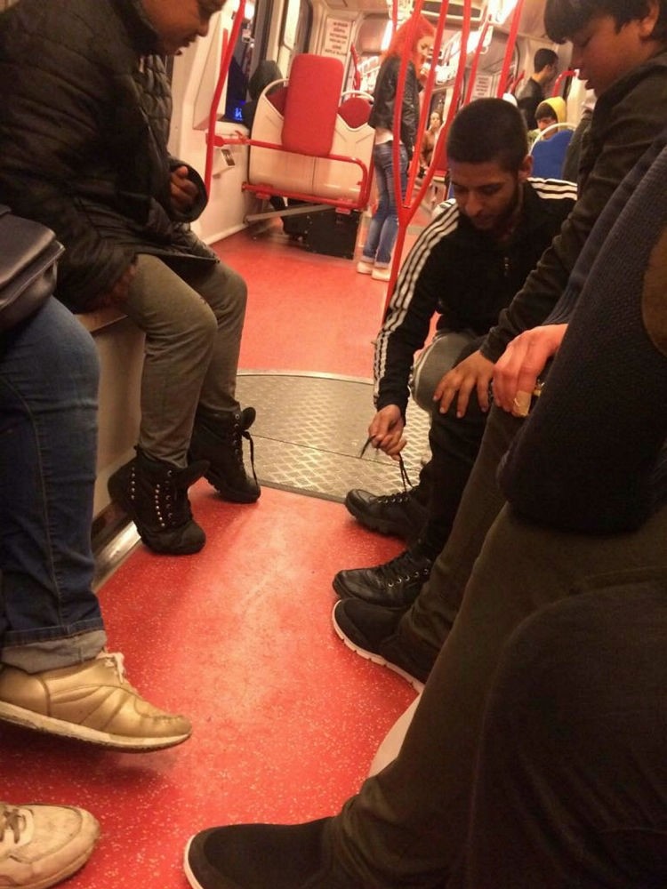 Al-Samarraie ties the laces of the shoes he handed to the boy.