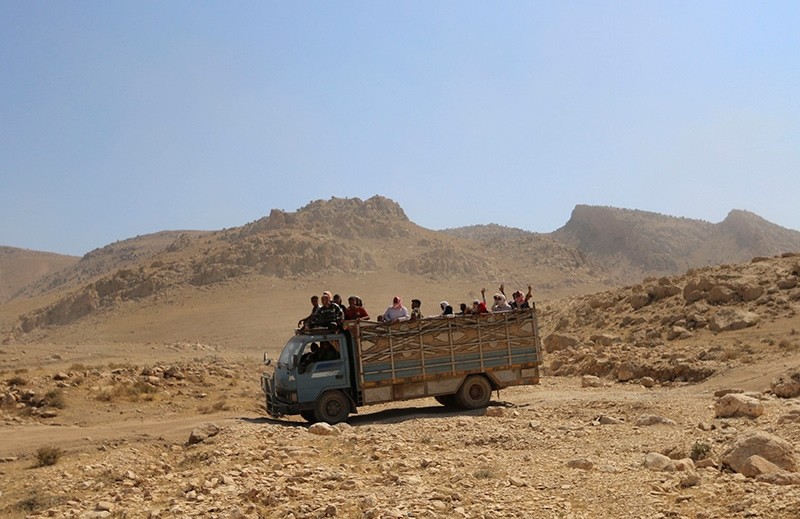 Displaced people from the Yazidi religious minority, fleeing violence from forces loyal to Daesh in Sinjar town, ride on a truck as they are evacuated from Mount Sinjar in northern Iraq, August 2014 (Reuters File Photo)
