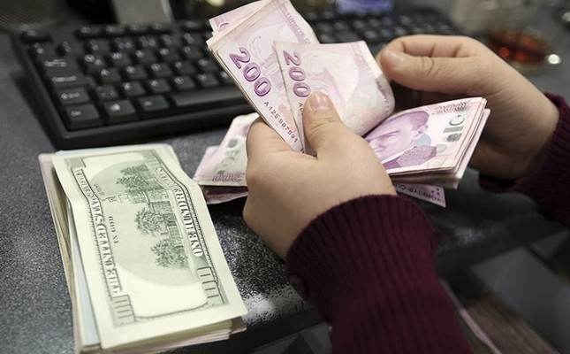 In this file photo taken Tuesday, Jan. 28, 2014, a woman counts U.S. dollar and Turkish lira banknotes at a currency exchange office in Istanbul, Turkey. (AP Photo)