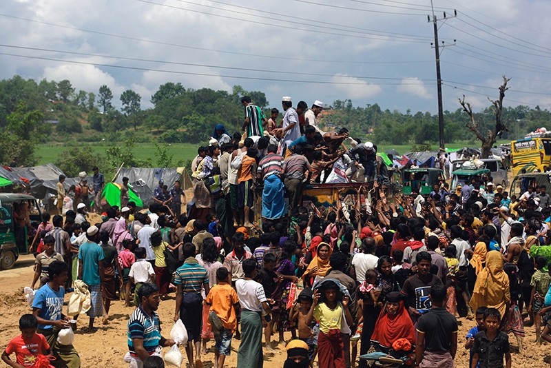 Rohingya refugees climb a truck to receive aid distributed by local organisations at Balukhali makeshift refugee camp in Cox's Bazar, Bangladesh (Reuters Photo)