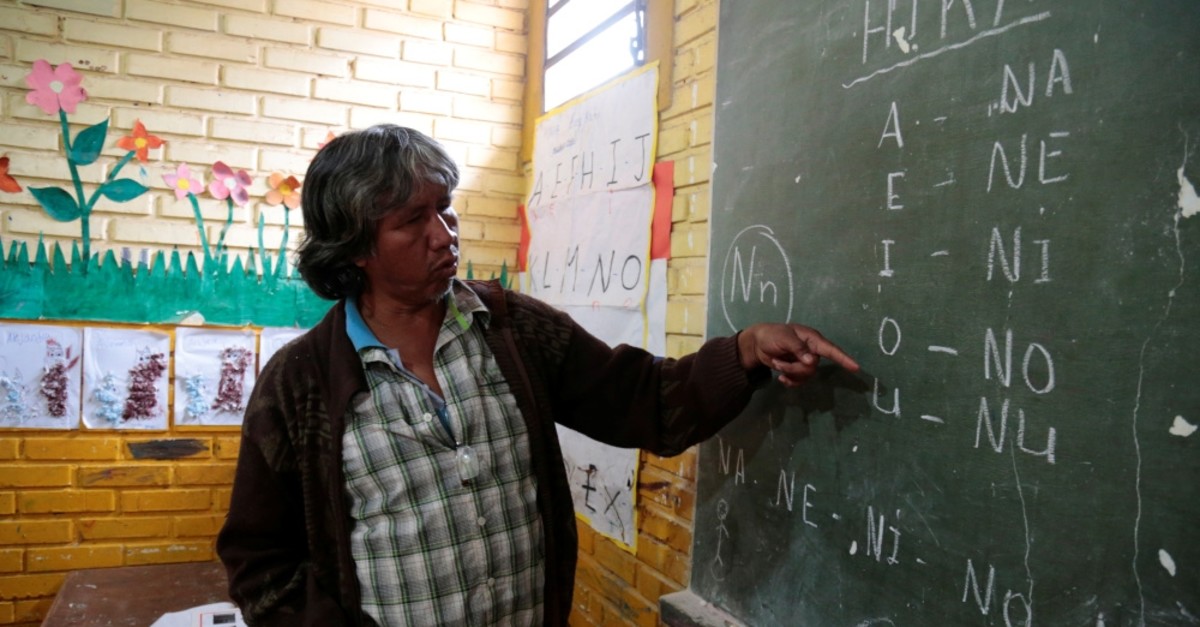Teacher Blas Duarte shows letters in the Maka language at a school used by children of the Paraguayan ethnic group Maka, in Paraguay.