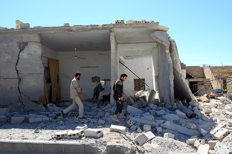 Civil defense members inspect the damage at a site hit by airstrikes on Tuesday, in the town of Khan Sheikhoun (Reuters Photo)